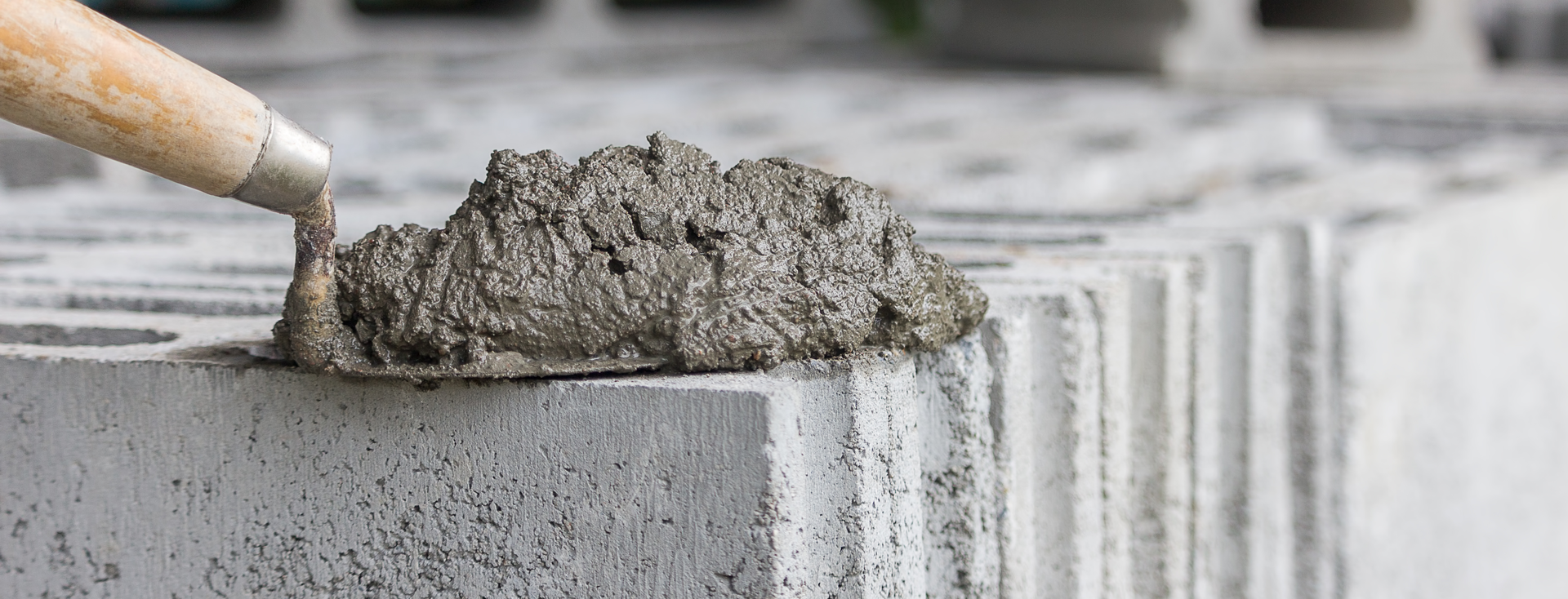 Bricklayer's trowel with mortar lies on stacked hollow concrete blocks